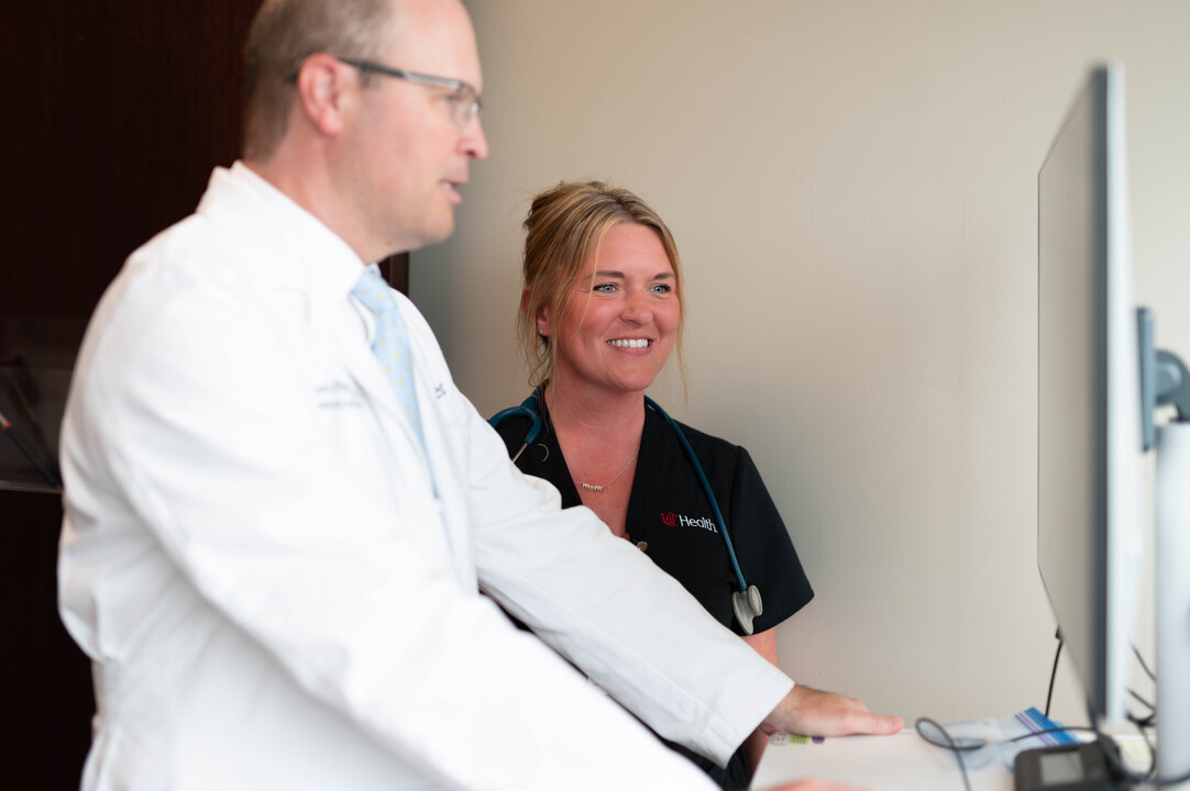 Surgeon and nurse review imaging with a patient