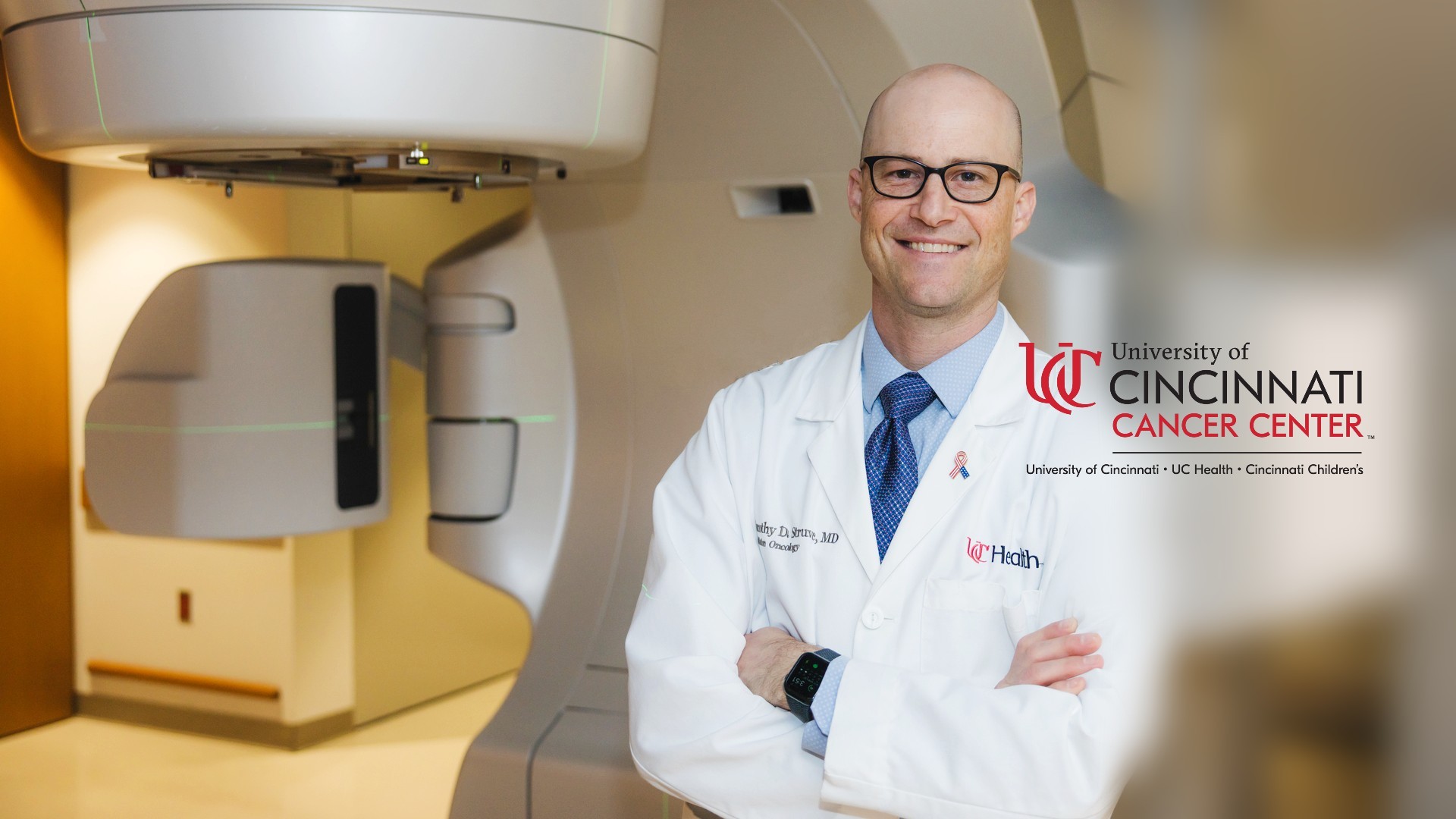 Physician in front of Varian beam proton therapy machine.