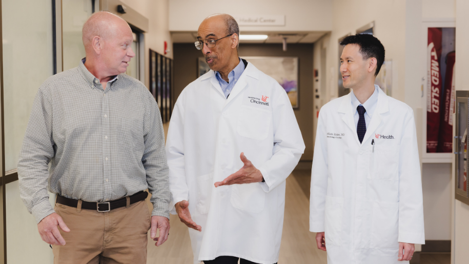 A patient walks through a hallway with two physicians at the University of Cincinnati Cancer Center.