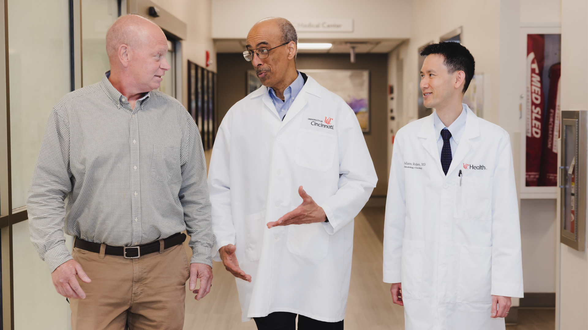 A patient walks through a hallway with two physicians at the University of Cincinnati Cancer Center.