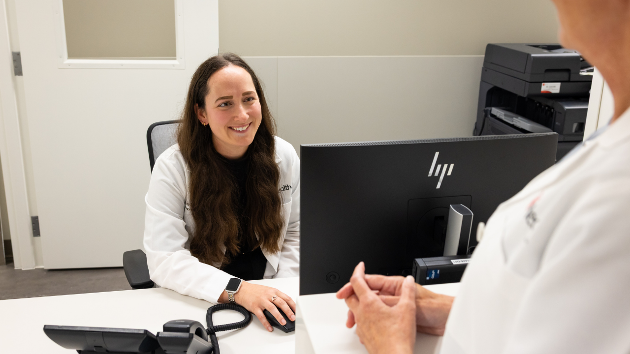 NP at UC Cancer Center speaks with patient at desk