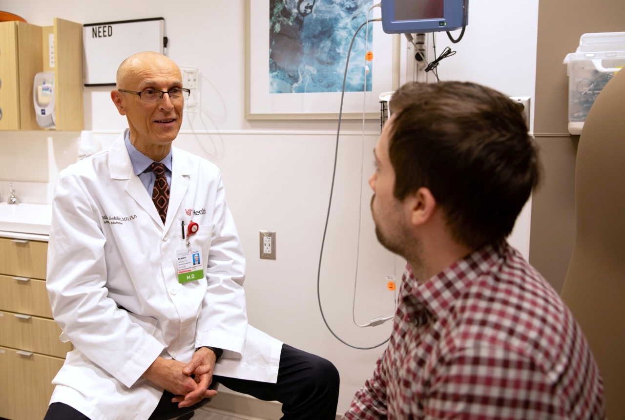 A physician talks with a patient in an exam room. 