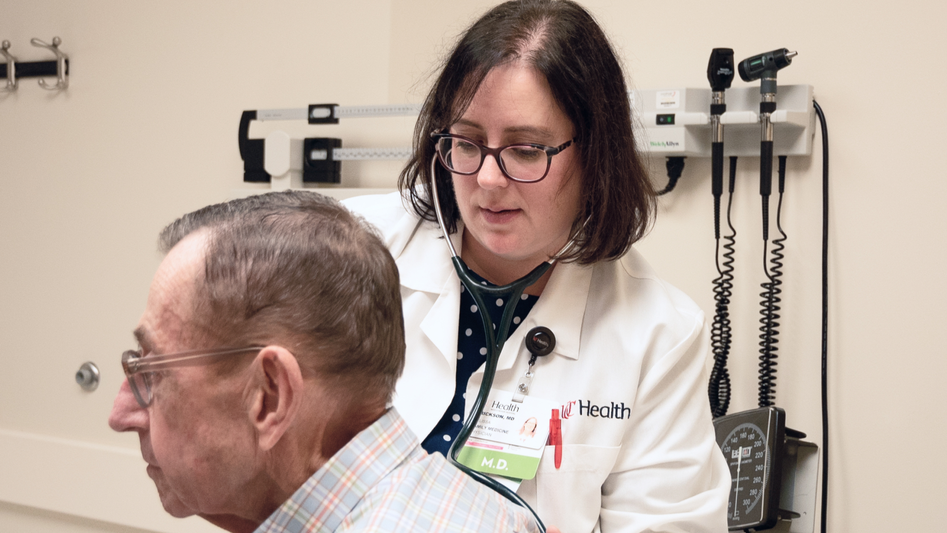 Physician examines a patient in an exam room. 