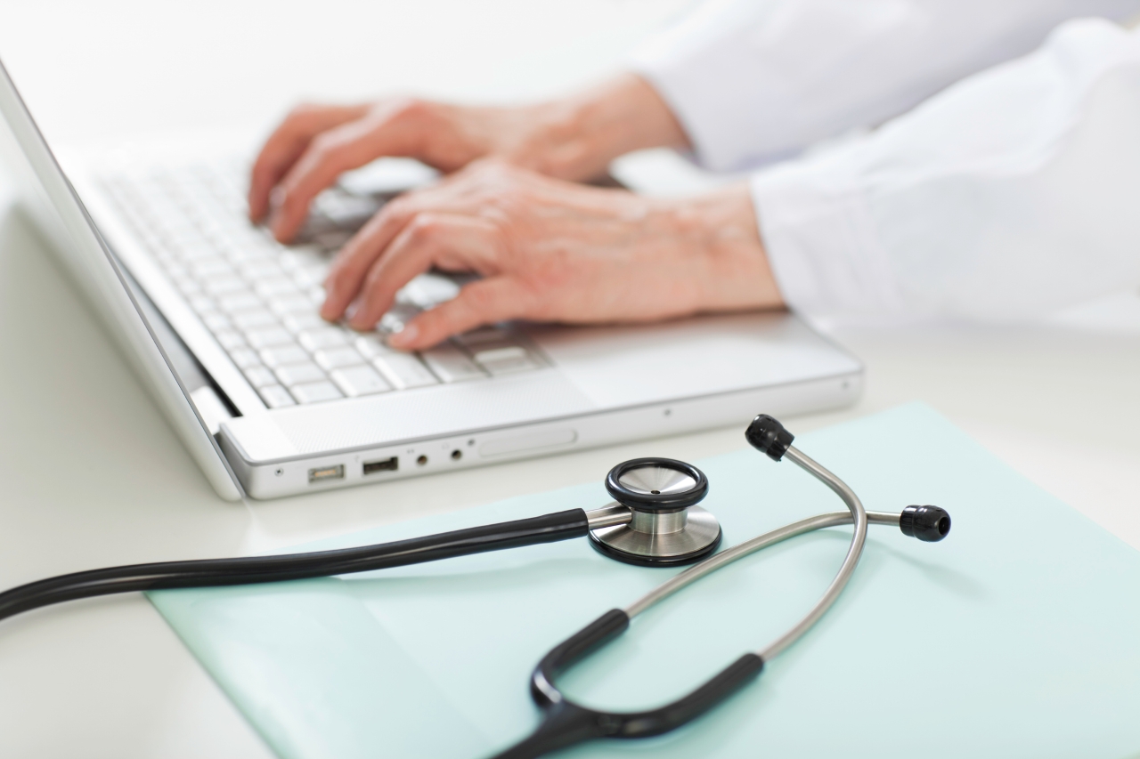 A medical provider types the keyboard on their laptop. 