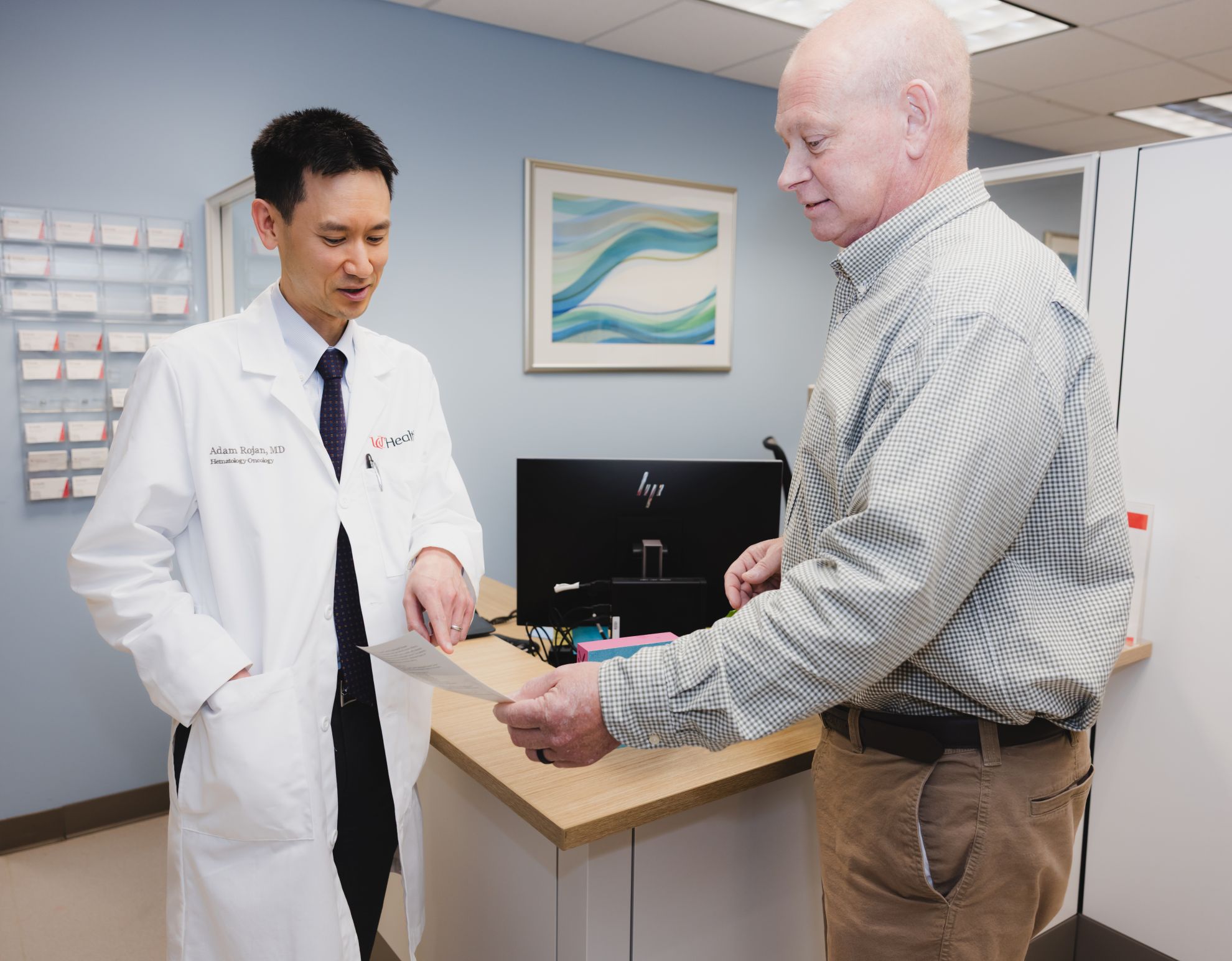 Physician and patient discuss information on a document. 