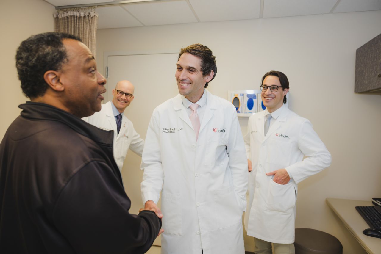 Physician greets a patient and shakes his hand. 