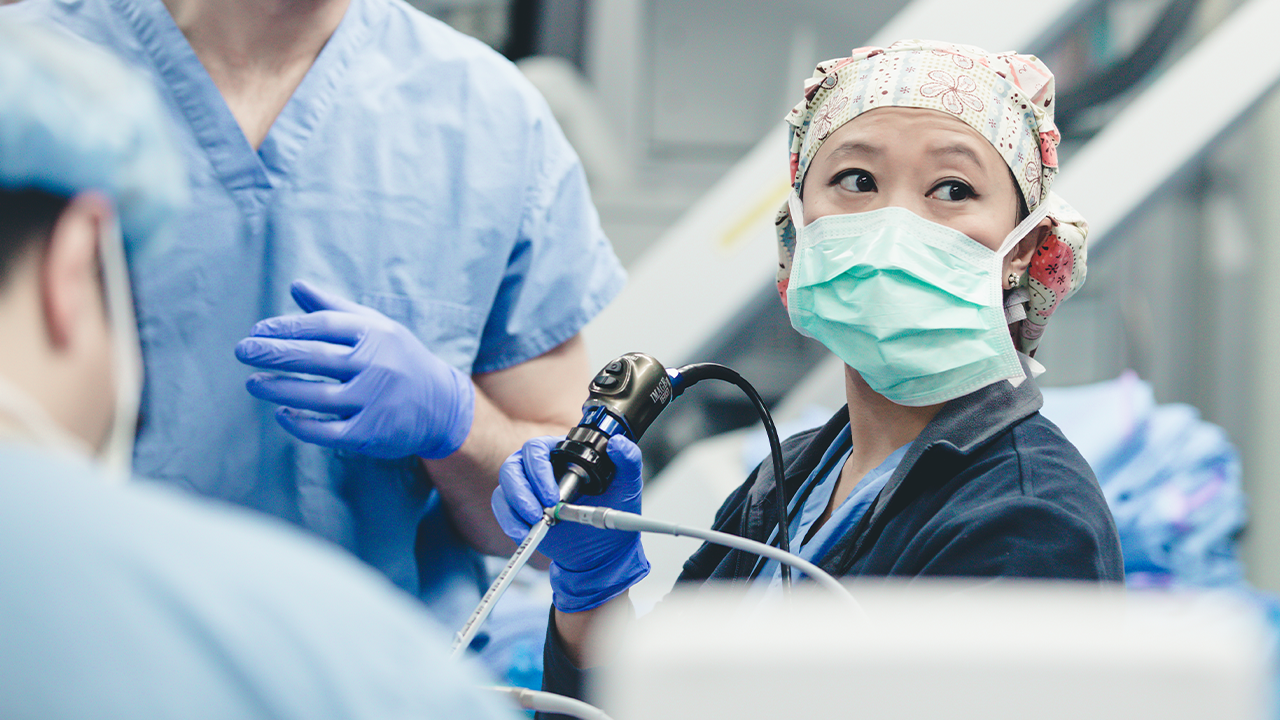 Physician performs surgery or medical procedure. 