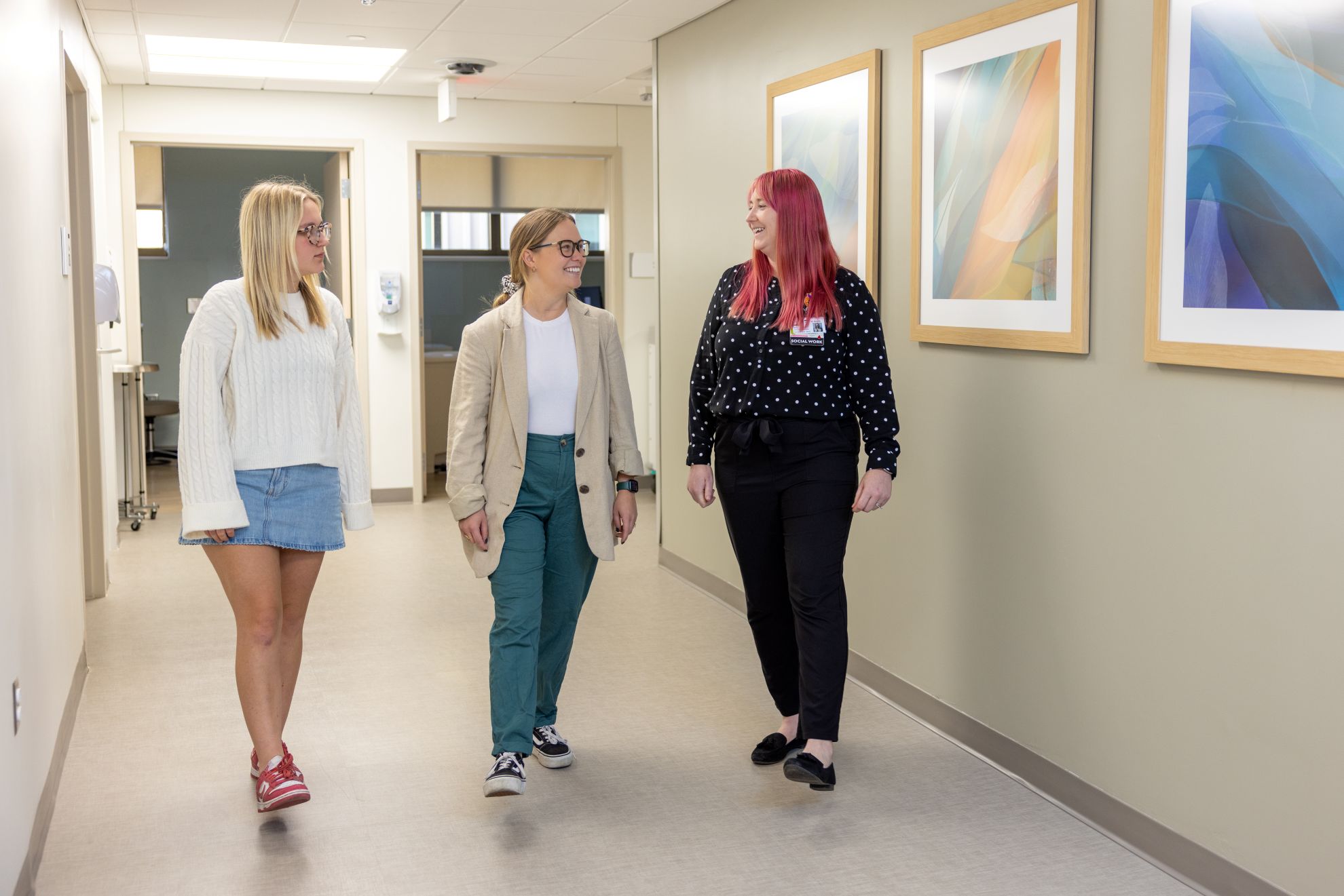 Patients and medical provider walk through hallway. 