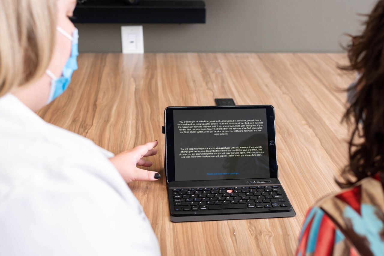 Physician and a patient look at a laptop. 