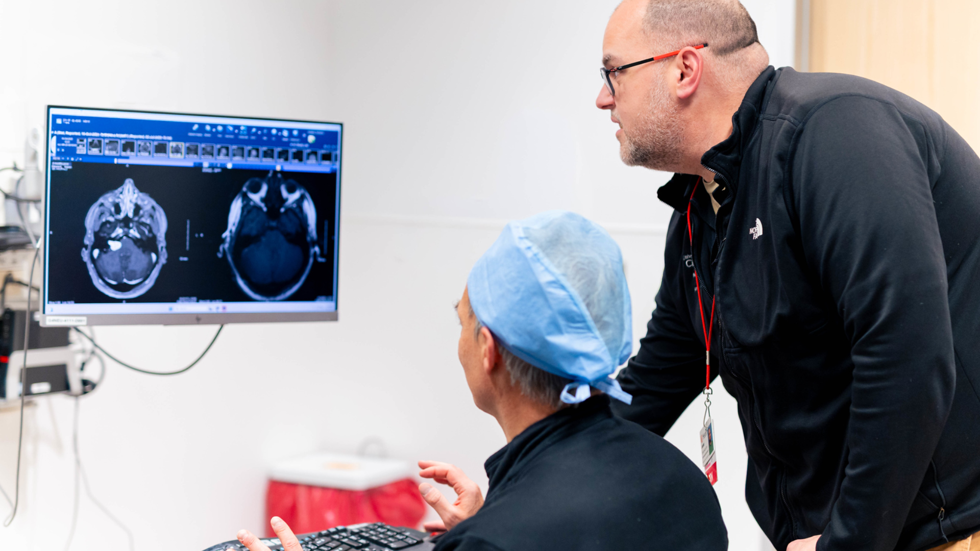 Physicians gathering around computer to review scans 