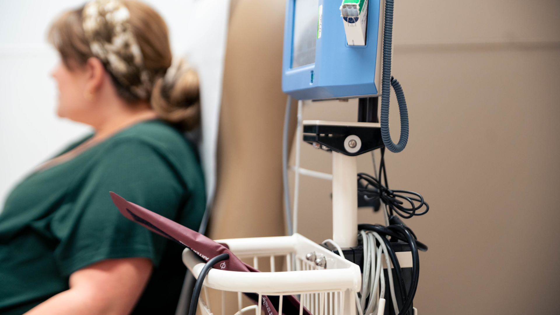 Nurse works on equipment in a medical room. 