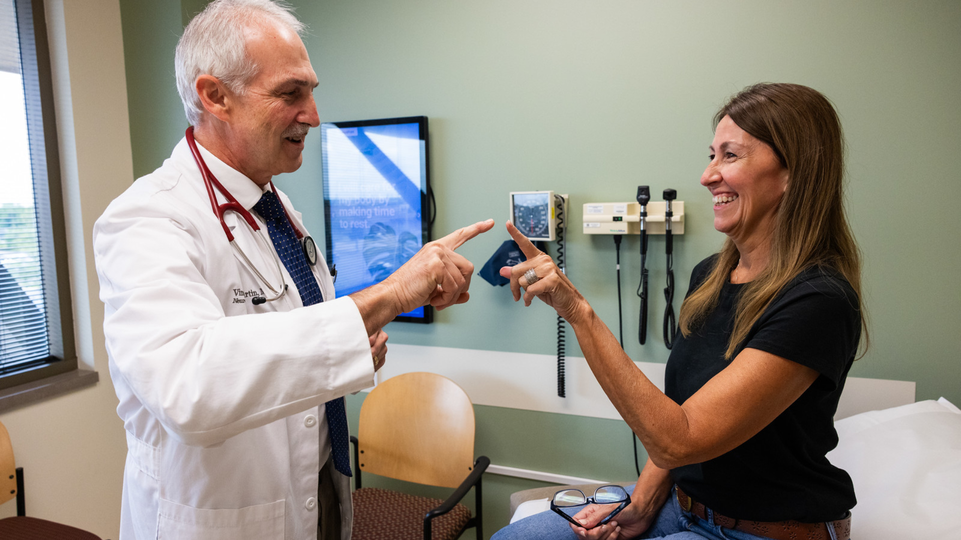 Physicians at UC Health in Cincinnati meet with a patient in an office