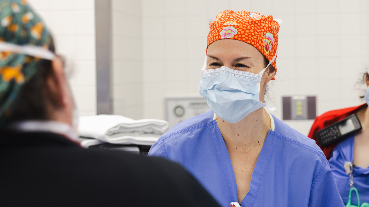 Physician in mask and scrubs in medical environment. 