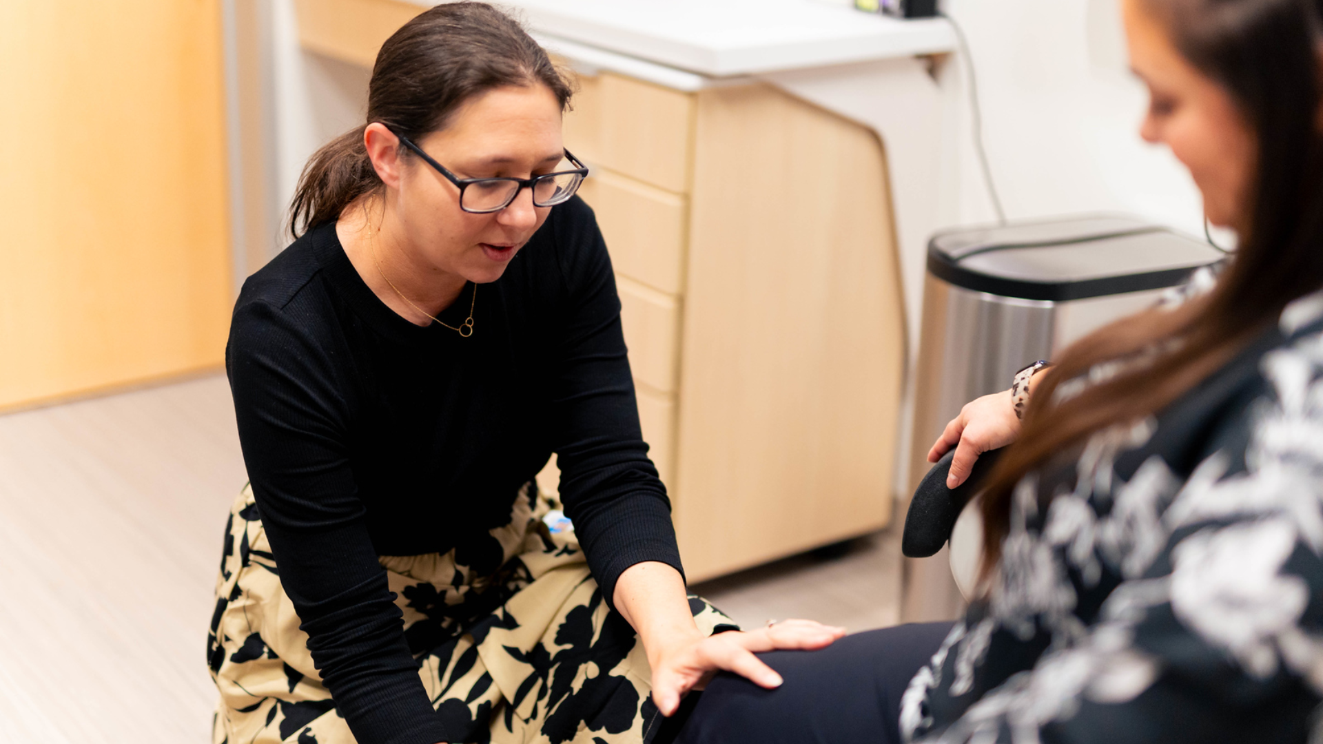 Physician examines patient's legs in a medical setting