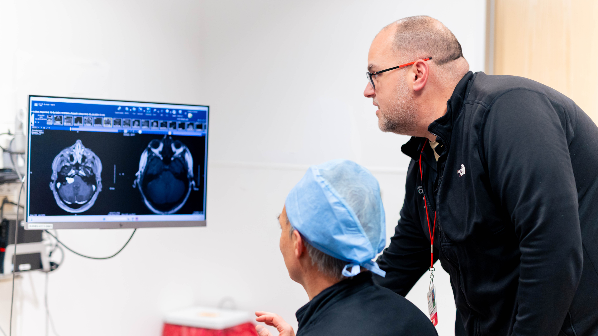 Physician and nurse navigator review a brain scan with a patient