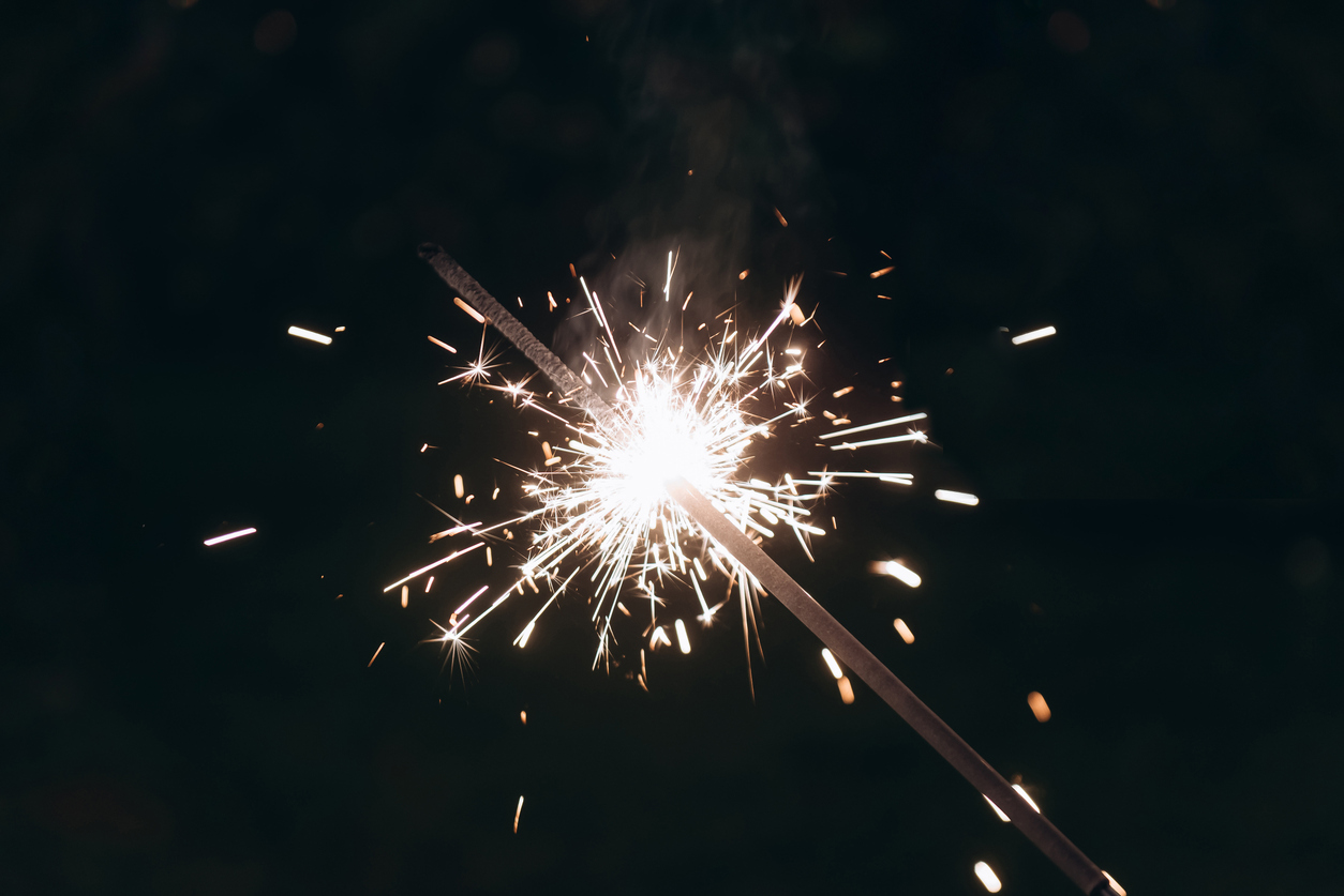 Sparkler lit across the dark sky.