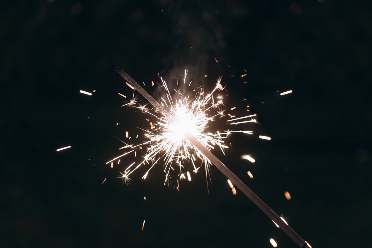 Sparkler lit across the dark sky.
