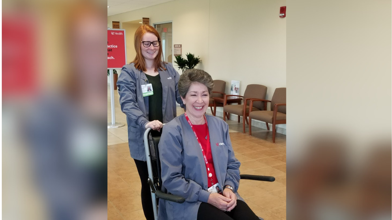 Adult volunteer pushing a patient in a wheelchair