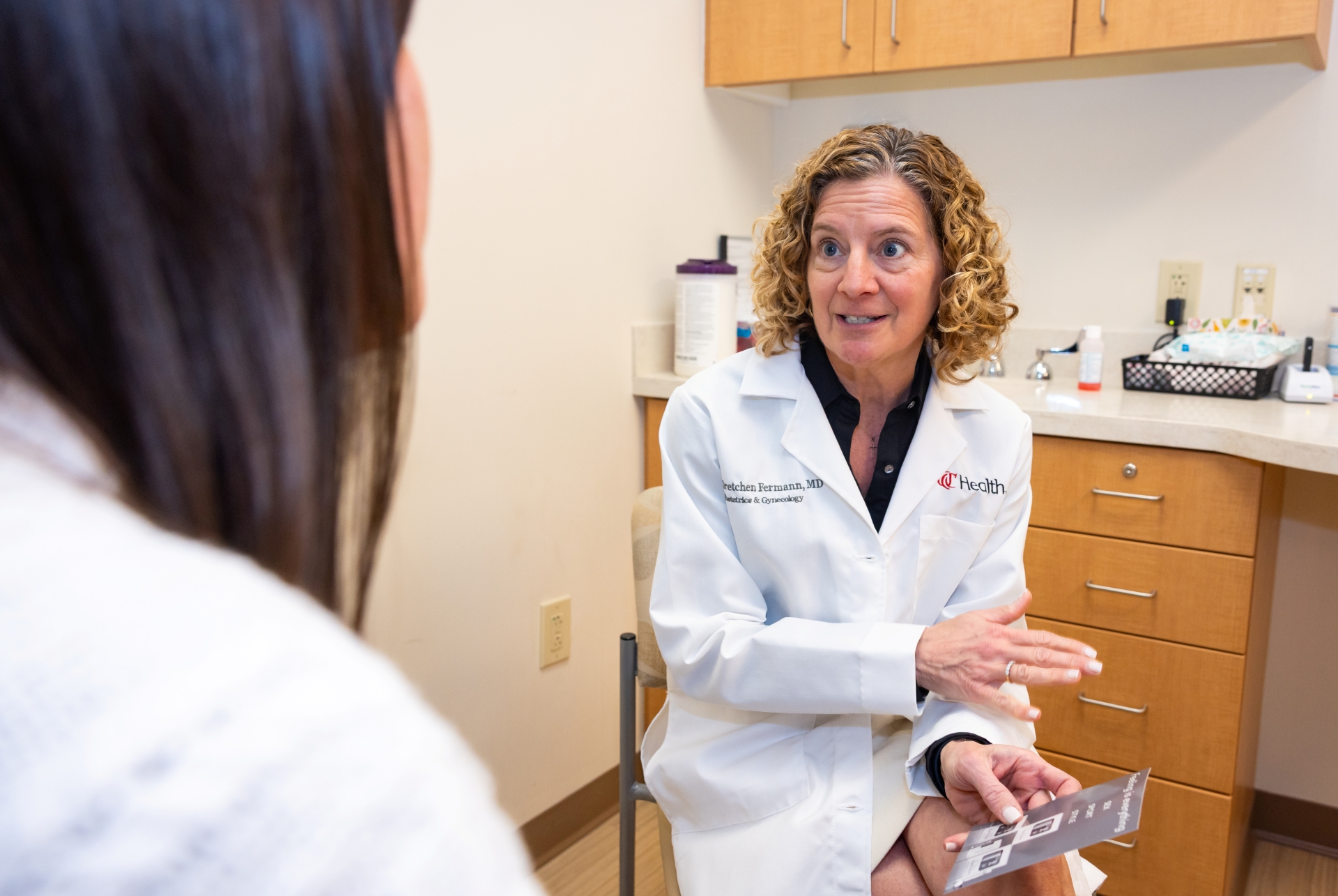 Physician talks with a patient in an exam room. 