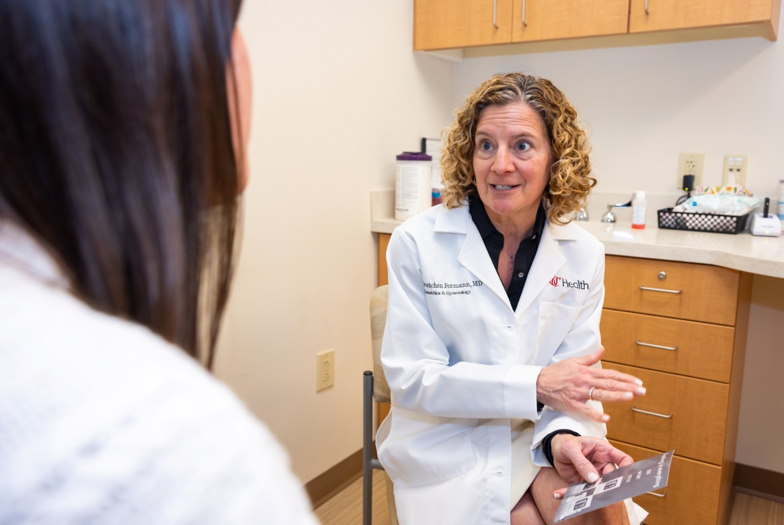 Physician talks with a patient in an exam room. 