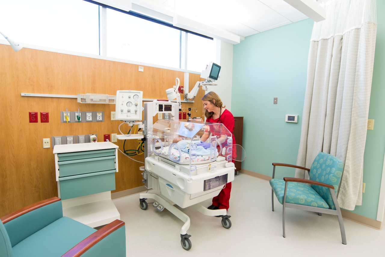 Medical provider looks looks after an infant in the special care nursery.