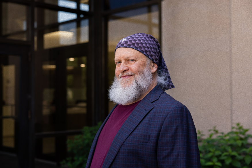 Tim, University of Cincinnati Cancer Center patient, smiles at camera wearing purple bandana.