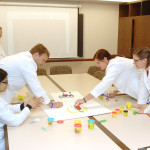 This type of non-threatening learning environment allows for "contingent teaching" by giving authority for the pace of instruction over to the audience. Pictured also on the table is a set of Play-Doh used by the new fellows to construct the mediastinum. Interactive learning that incorporates team-based construction teaches detailed lessons about anatomy that will be used in upcoming procedures.
