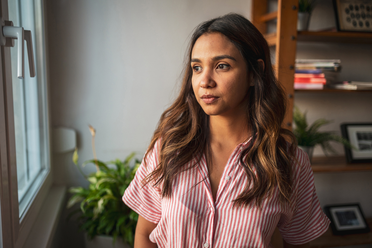 Woman in her home looking out a window